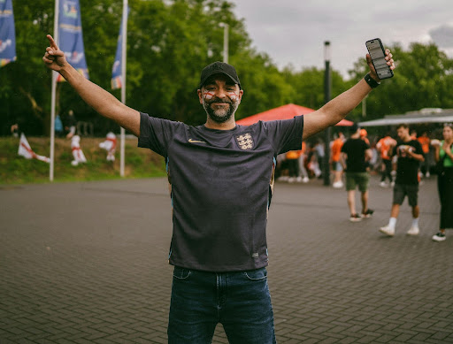 A football fan with arms apart in front of a crowd